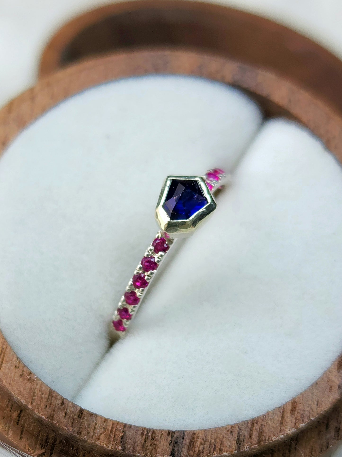 Dark blue horizontal natural winza sapphire, sterling silver ring, set in 10 karat yellow gold bezel with 12 synthetic 1.5mm rubies