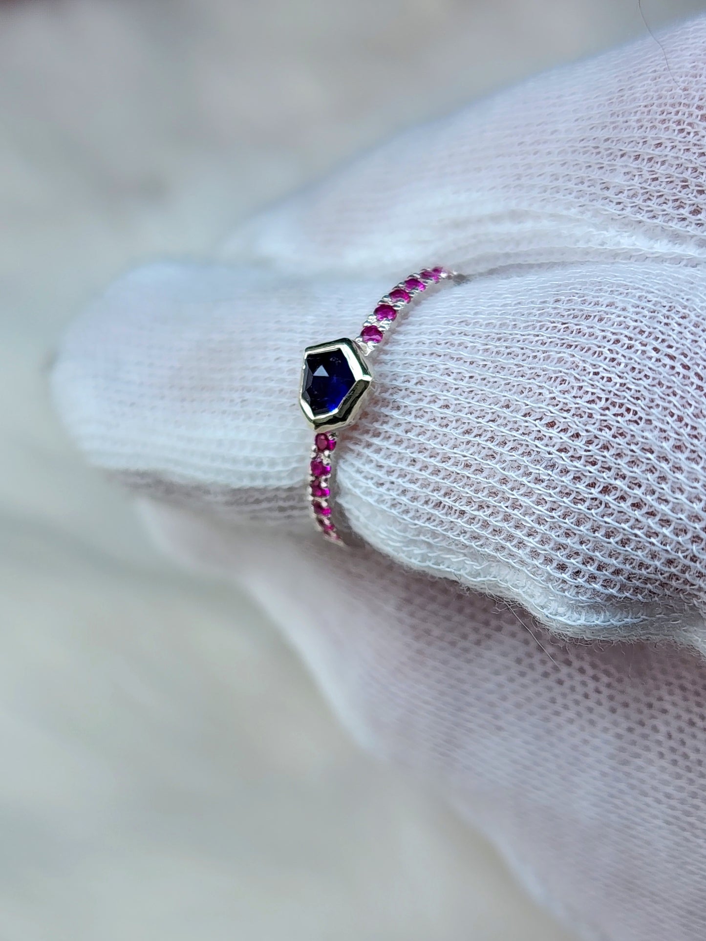 Dark blue horizontal natural winza sapphire, sterling silver ring, set in 10 karat yellow gold bezel with 12 synthetic 1.5mm rubies