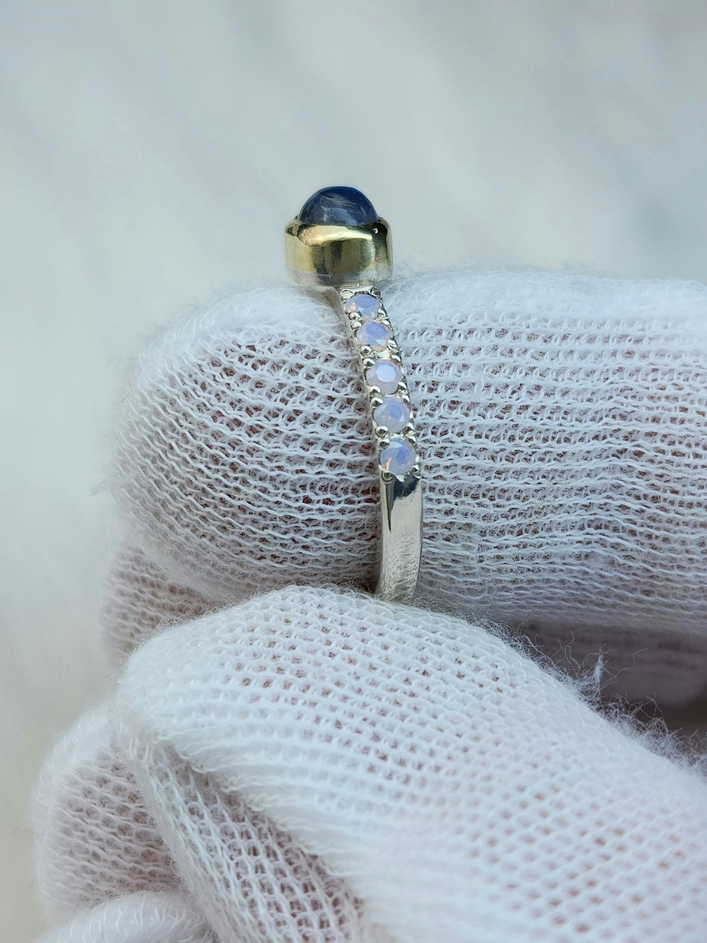 Horizontal set natural rainbow moonstone in 14 karat yellow gold bezel, with ten 2mm pave set synthetic pink opals