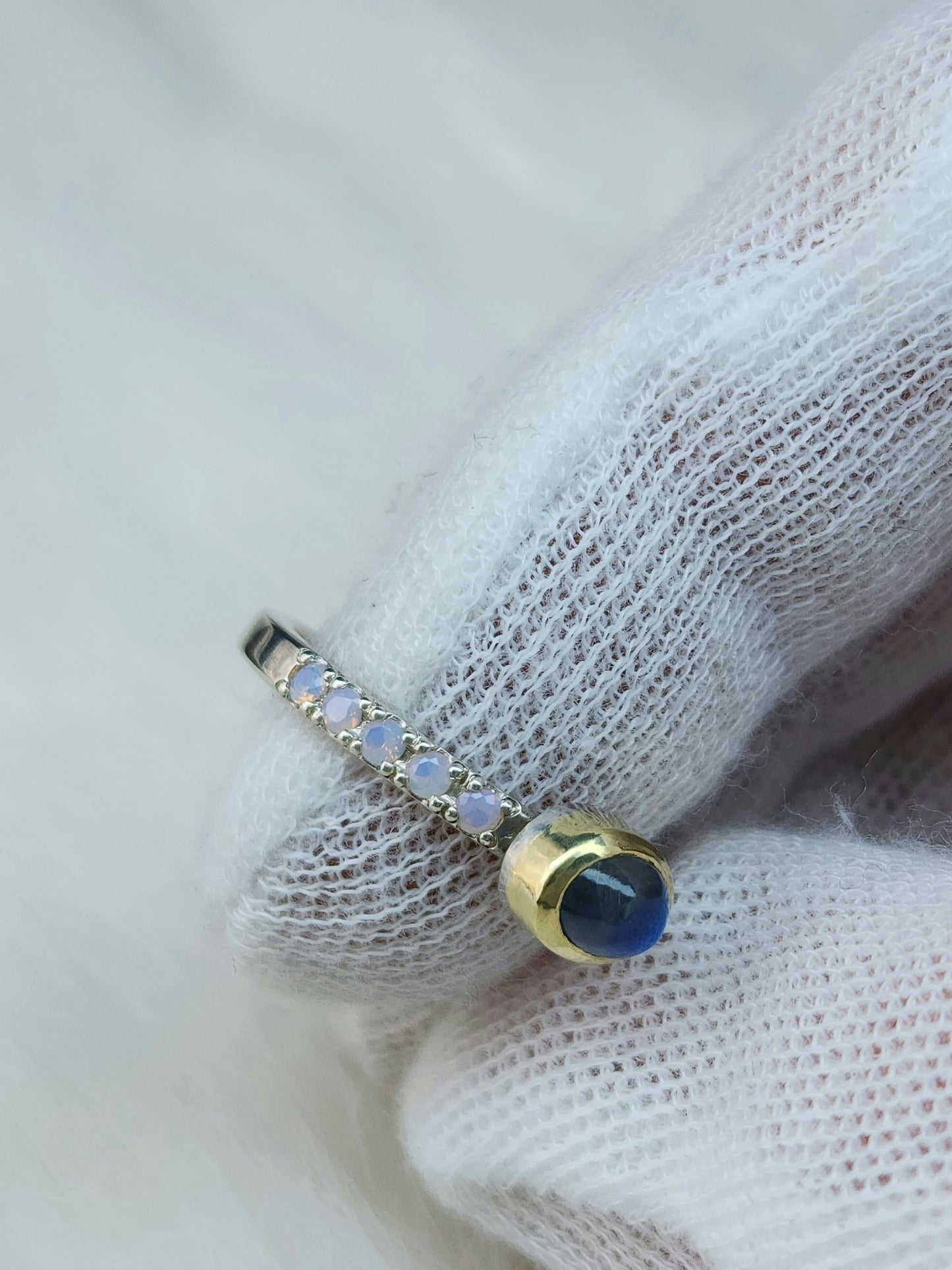 Horizontal set natural rainbow moonstone in 14 karat yellow gold bezel, with ten 2mm pave set synthetic pink opals