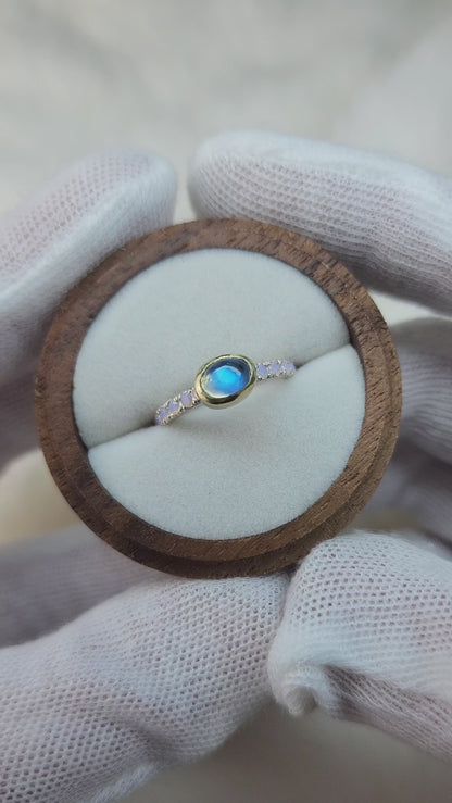 Horizontal set natural rainbow moonstone in 14 karat yellow gold bezel, with ten 2mm pave set synthetic pink opals